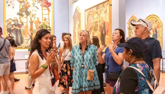Tour group with guide at Accademia Gallery, Florence, viewing Michelangelo's David statue.