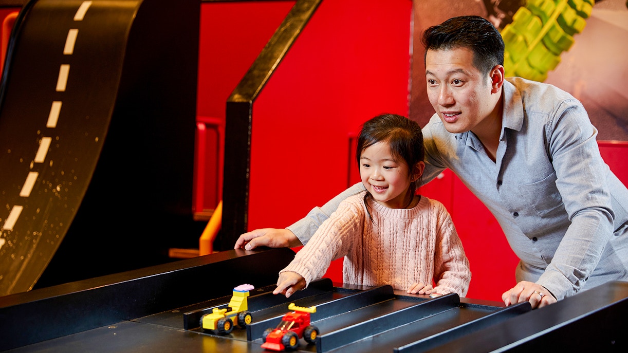 Father and daughter playing with racing cars at Legoland Melbourne, Australia.