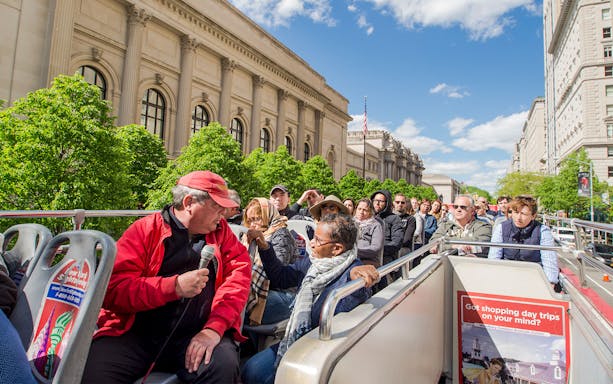 Tourists on a New York City hop-on hop-off bus near the Metropolitan Museum of Art.