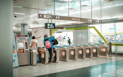 Travelers using KORAIL Pass at Seoul train station turnstiles.