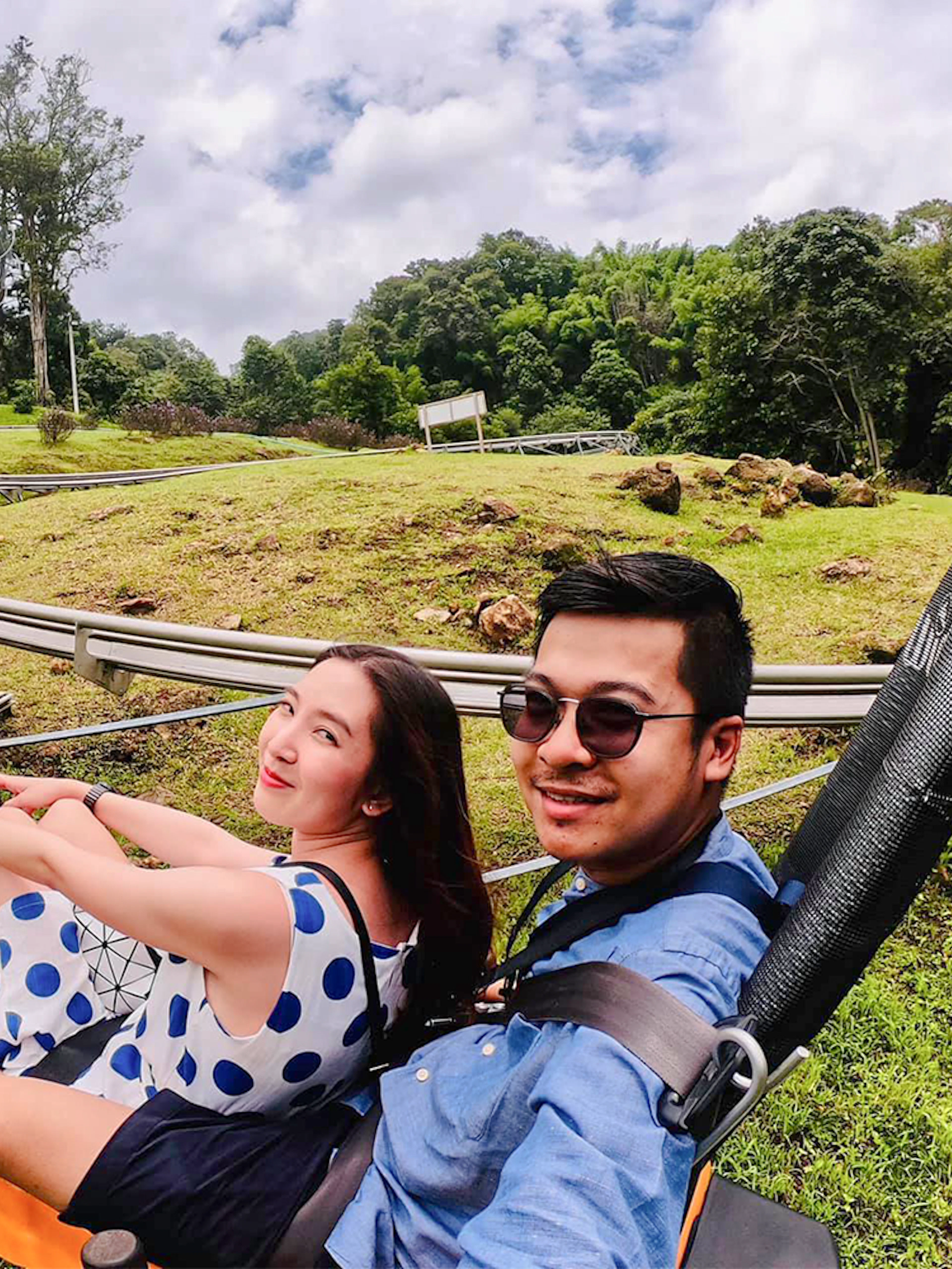 Couple enjoying a scenic coaster ride through lush greenery.