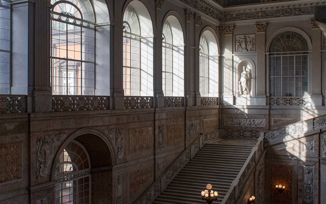 Grand staircase and arched windows inside Museo di Capodimonte, Naples.