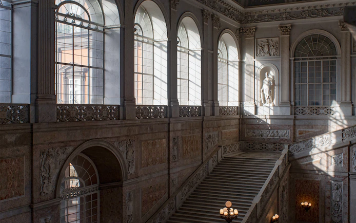 Grand staircase and arched windows inside Museo di Capodimonte, Naples.
