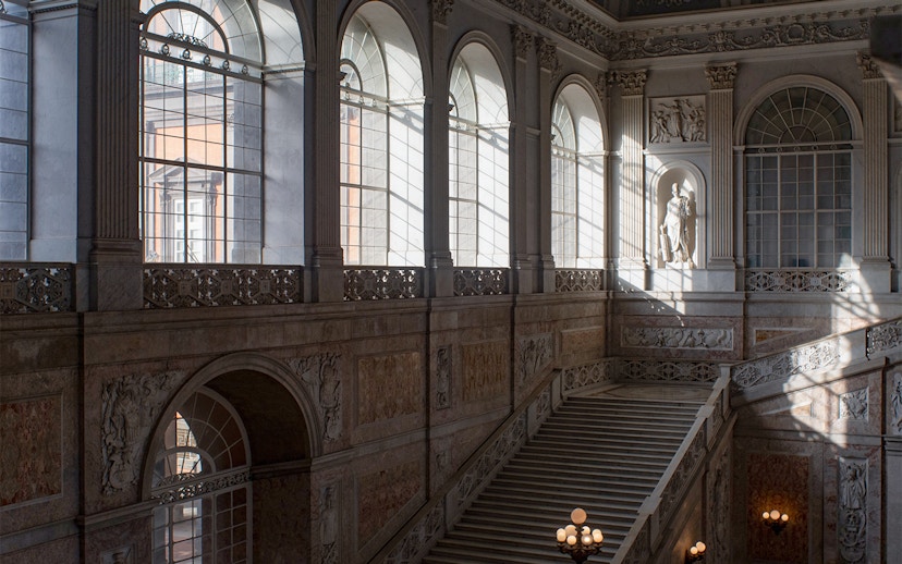 Grand staircase and arched windows inside Museo di Capodimonte, Naples.