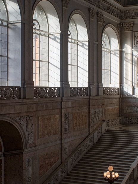 Grand staircase and arched windows inside Museo di Capodimonte, Naples.