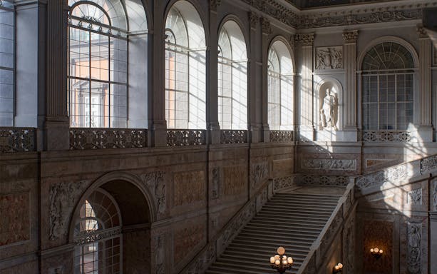 Grand staircase and arched windows inside Museo di Capodimonte, Naples.