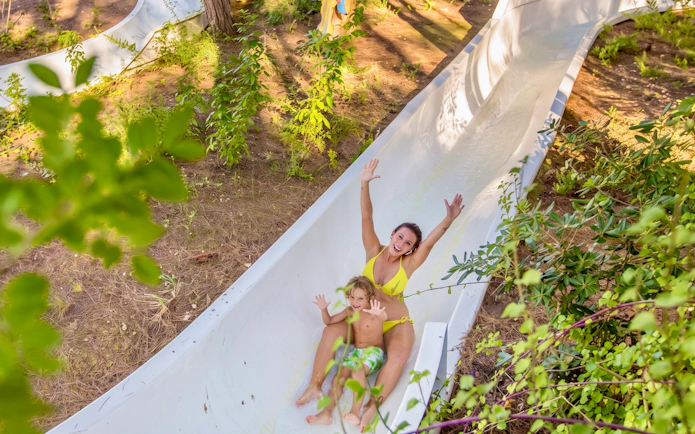 Family sliding down zig-zag slide at Aqualandia Benidorm, Spain.