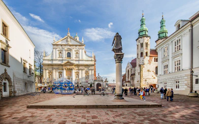 Krakow Old Town square with Saint Mary's Basilica and tourists exploring.