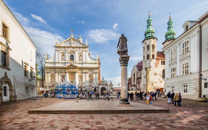 Krakow Old Town square with Saint Mary's Basilica and tourists exploring.