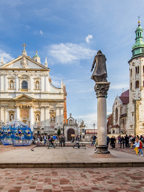 Krakow Old Town square with Saint Mary's Basilica and tourists exploring.