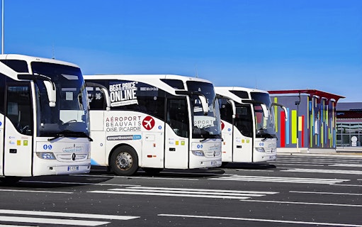 Aerobus Paris parked at airport with colorful terminal building in background.
