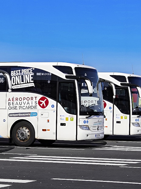 Aerobus Paris parked at airport with colorful terminal building in background.