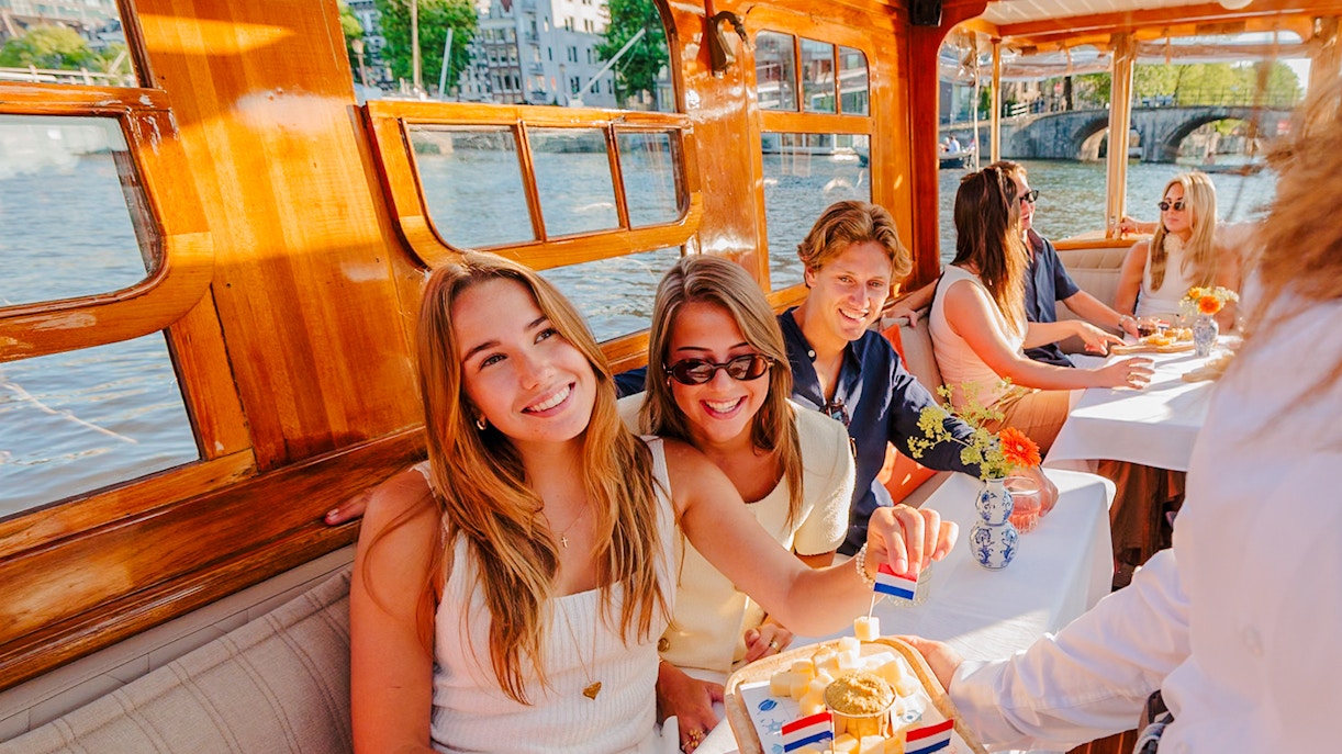 Guests enjoying cheese and wine on a classic Amsterdam cruise.
