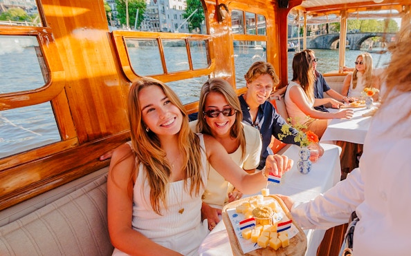 Guests enjoying cheese and wine on a classic Amsterdam cruise.