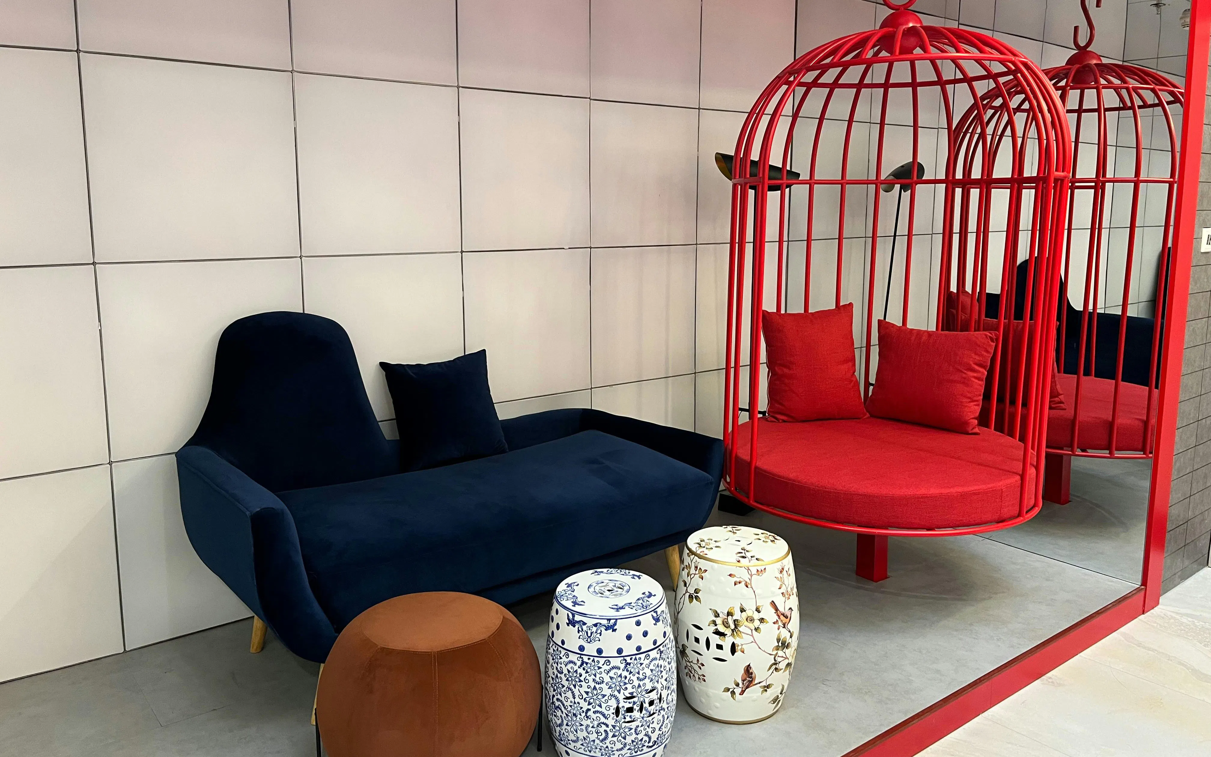 Seating area with blue sofa and red hanging chairs at Barcelo Lounge, Beijing Capital Airport.