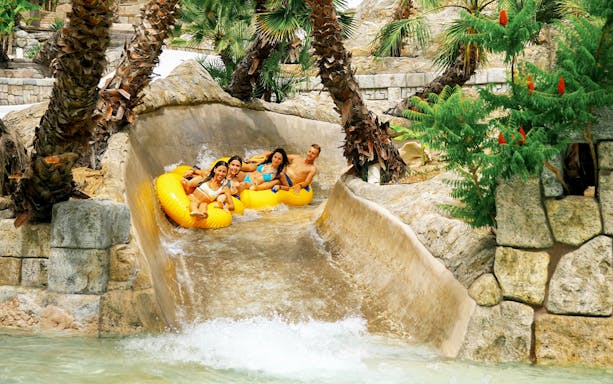 Tourists on yellow tubes enjoying a water slide at Caribe Bay.