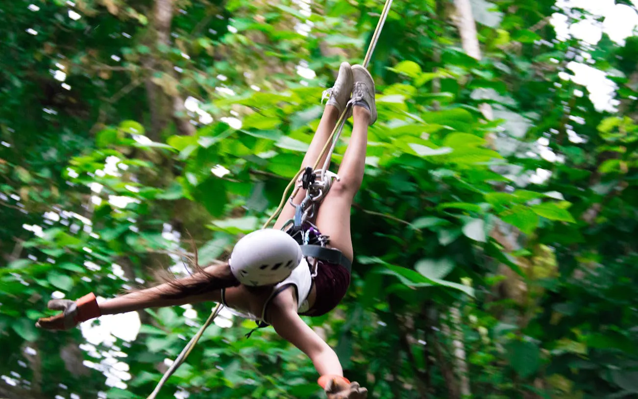 Person ziplining through rainforest canopy near Manuel Antonio.
