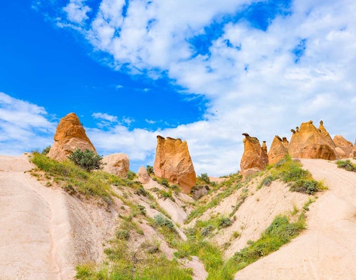 Rock formations in Devrent Imagination Valley, Cappadocia, under a blue sky.
