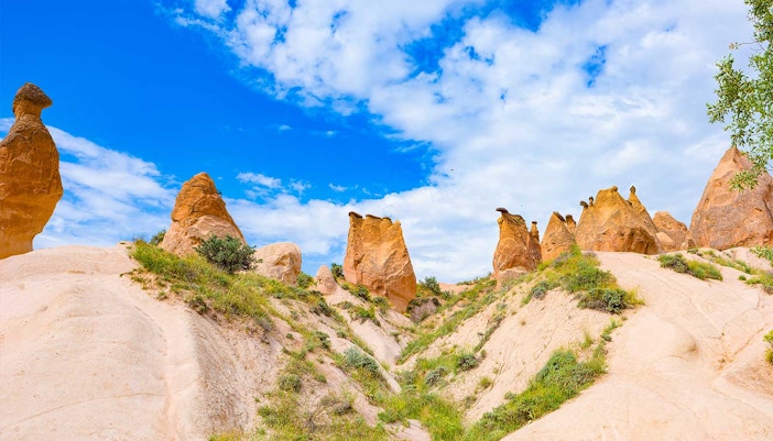 Rock formations in Devrent Imagination Valley, Cappadocia, under a blue sky.