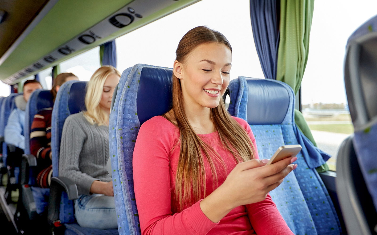 Passengers on a shuttle bus from Amsterdam using mobile devices.