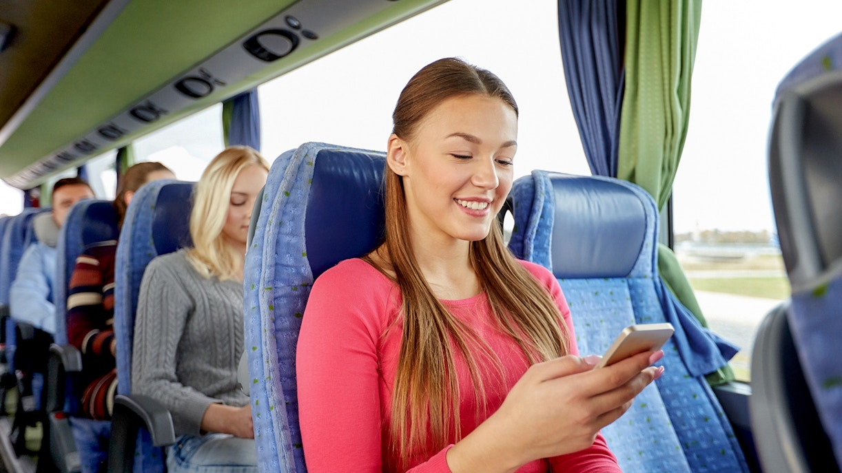 Passengers on a shuttle bus from Amsterdam using mobile devices.
