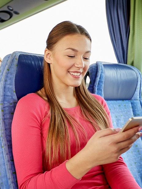 Passengers on a shuttle bus from Amsterdam using mobile devices.