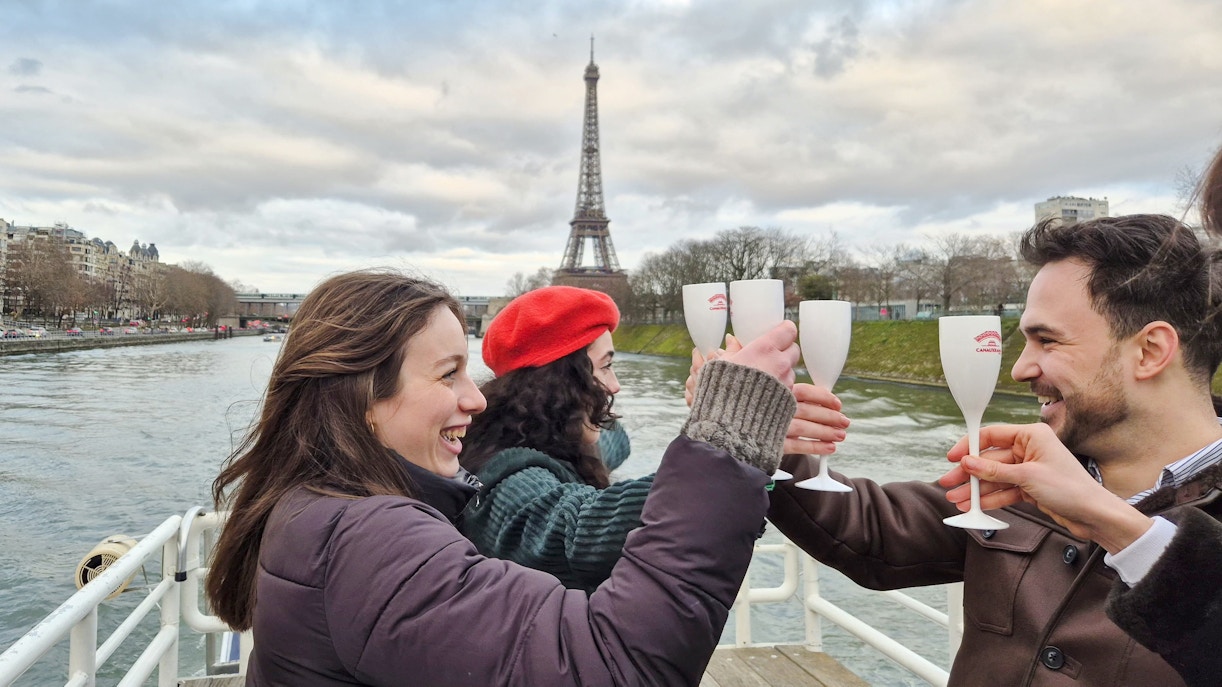 People toasting on a Seine River cruise with the Eiffel Tower in the background, Paris, France.