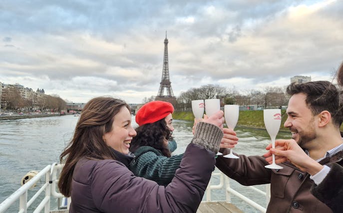 People toasting on a Seine River cruise with the Eiffel Tower in the background, Paris, France.