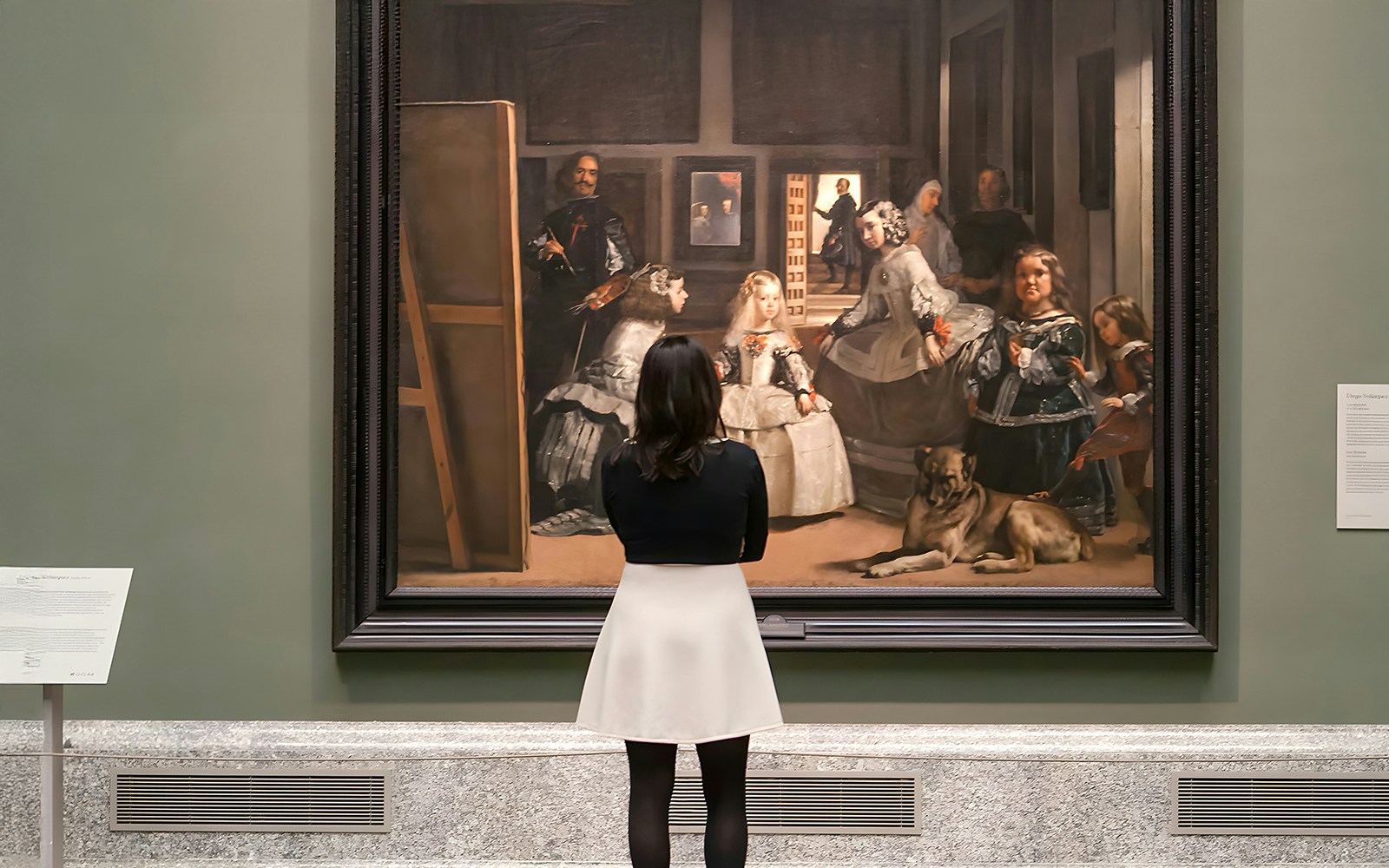 Visitors admiring classical art in Prado Museum, Madrid, Spain.