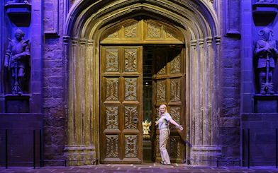 Entrance to the Great Hall with ornate wooden doors and stone statues.