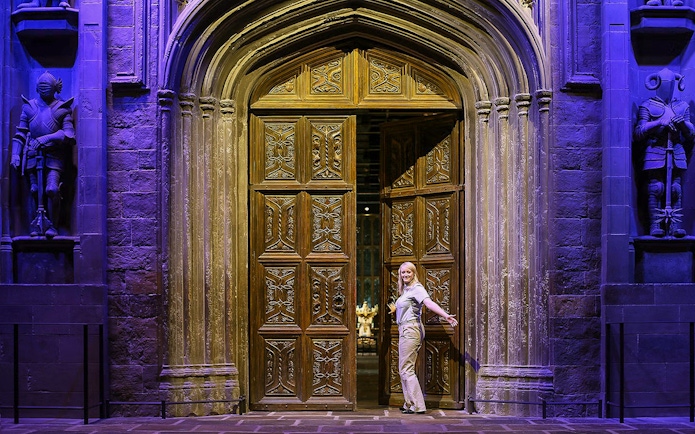 Entrance to the Great Hall with ornate wooden doors and stone statues.
