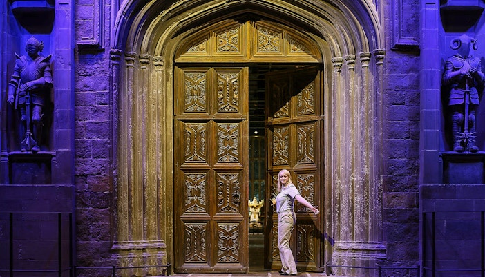 Entrance to the Great Hall with ornate wooden doors and stone statues.