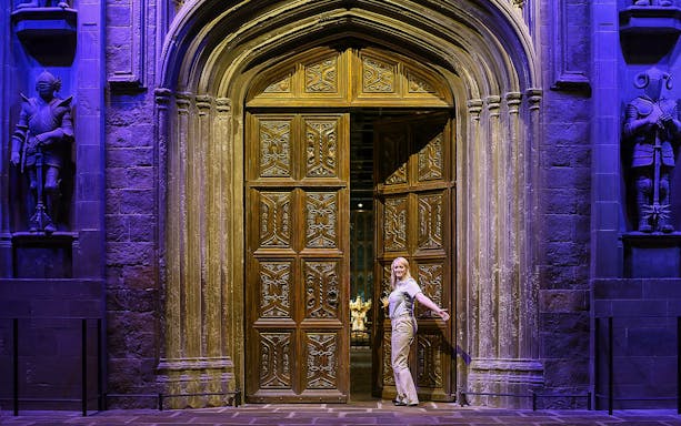 Entrance to the Great Hall with ornate wooden doors and stone statues.