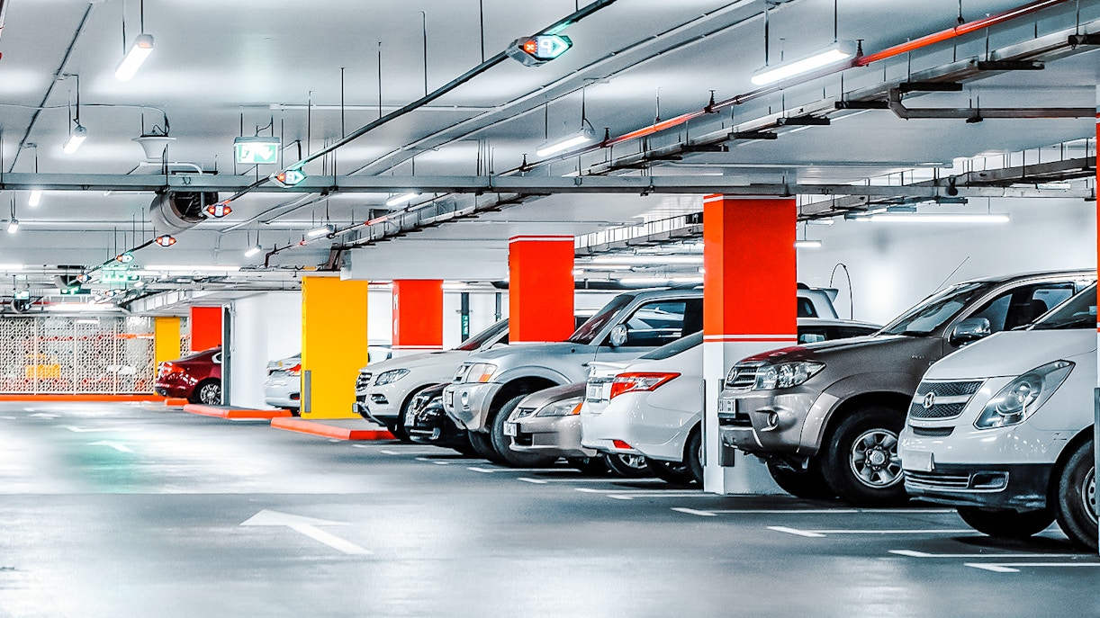 Parking lot filled with cars near a popular tourist attraction in the city.