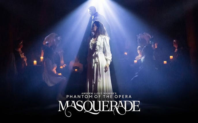 Stage scene from Phantom of the Opera's Masquerade on Broadway, featuring actors in spotlight.