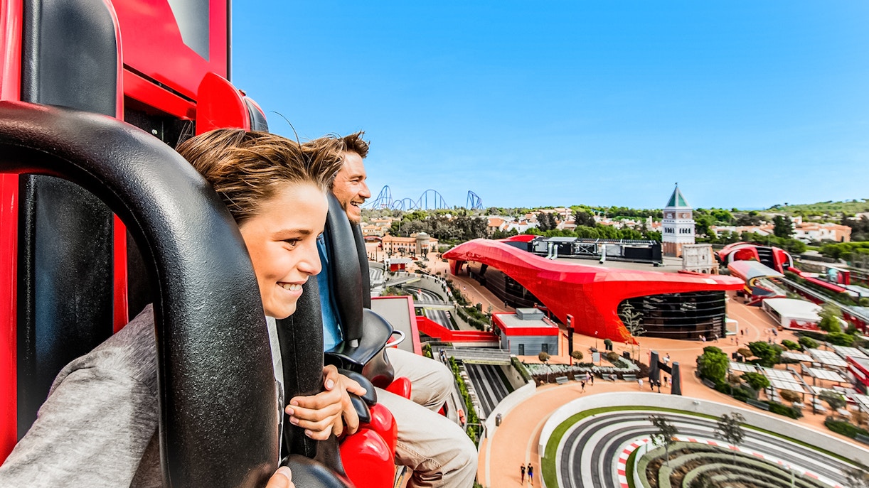 PortAventura roller coaster with riders in Salou, Spain, showcasing thrilling loops and vibrant park scenery.