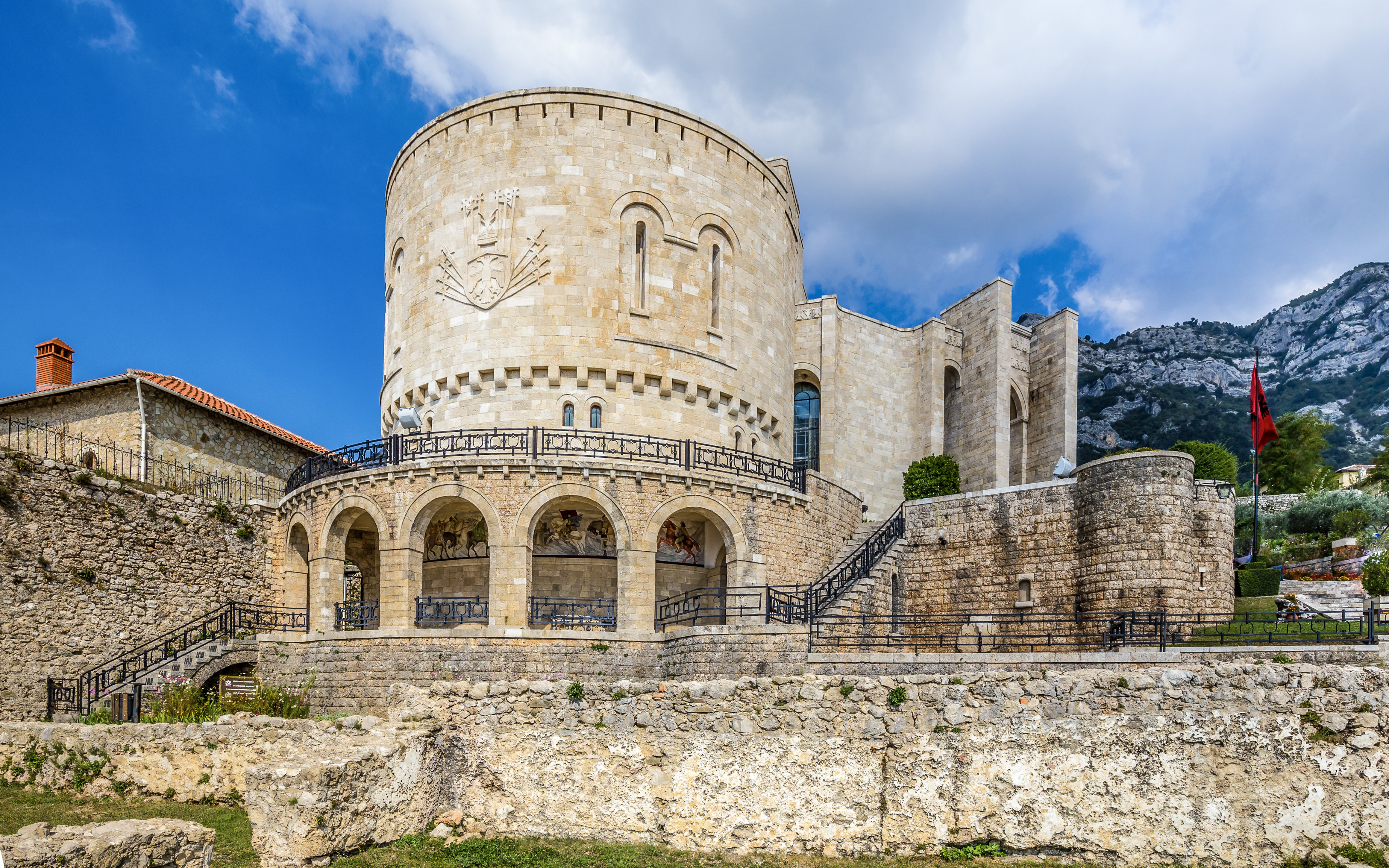 Kruje Castle with stone walls and Albanian flag, Kruje, Albania.