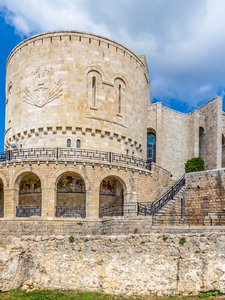 Kruje Castle with stone walls and Albanian flag, Kruje, Albania.
