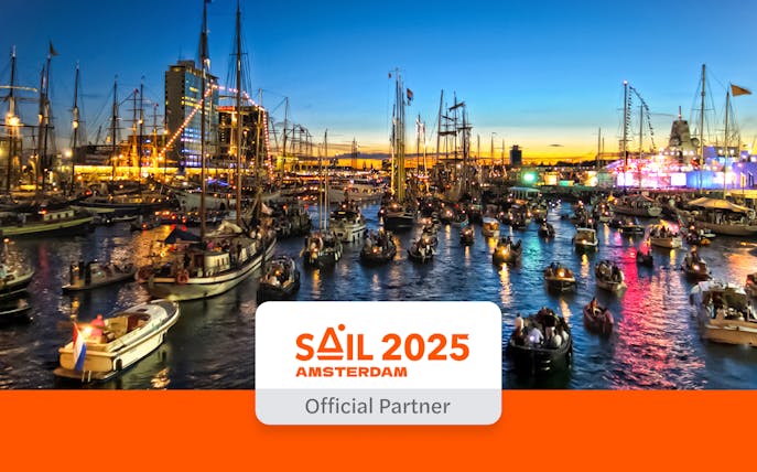 Boats illuminated at night during SAIL Amsterdam 2025 cruise.