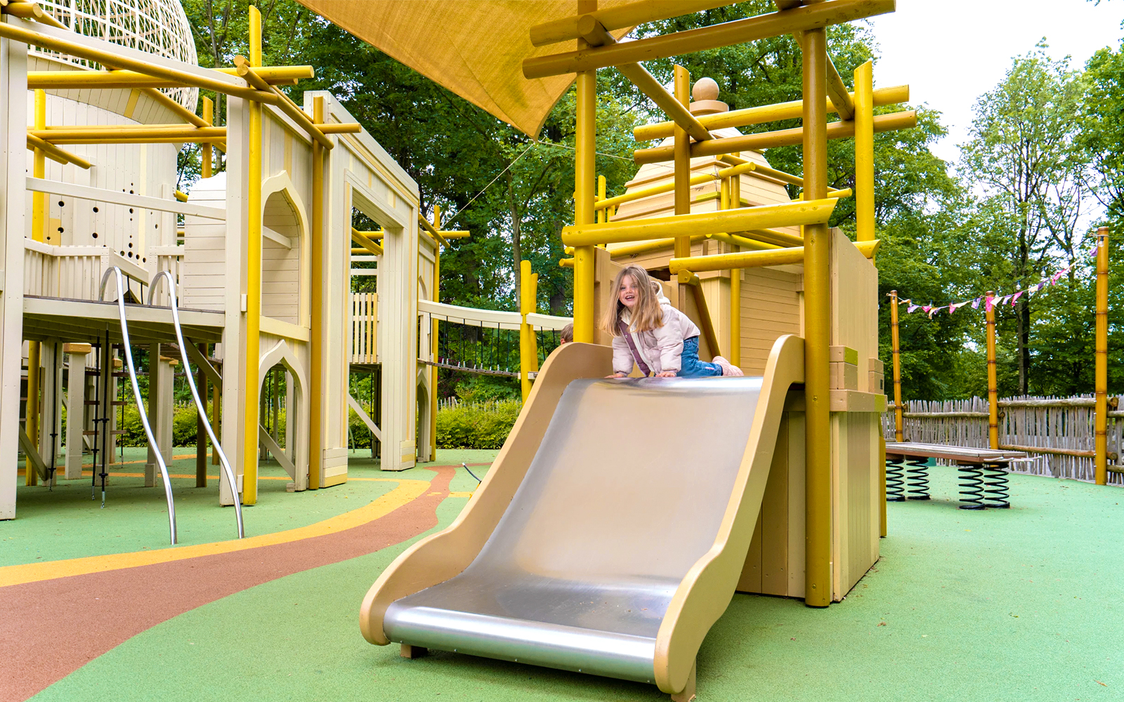 Child playing on slide at Hampi-themed playground in Bellewaerde Park, India zone.