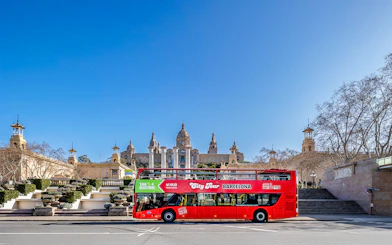 Red double-decker bus in front of the National Palace, Barcelona.