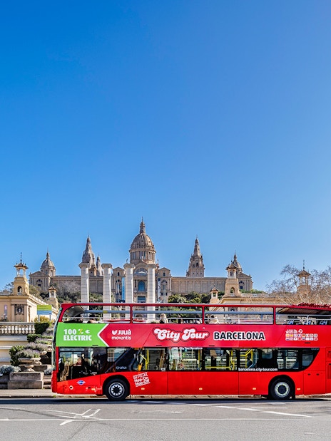Red double-decker bus in front of the National Palace, Barcelona.