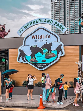 99 Wonderland Park entrance with visitors and wildlife sign in Malaysia.