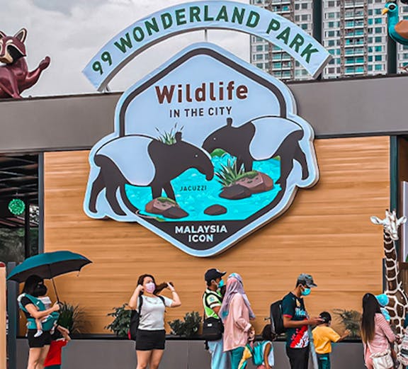 99 Wonderland Park entrance with visitors and wildlife sign in Malaysia.