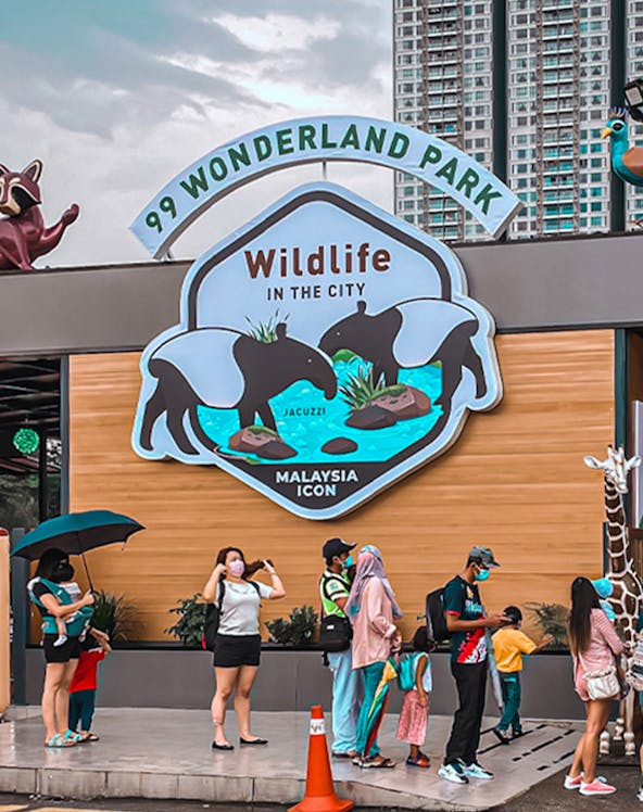 99 Wonderland Park entrance with visitors and wildlife sign in Malaysia.
