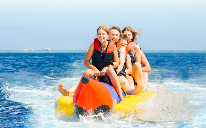Group enjoying a banana boat ride on the ocean.