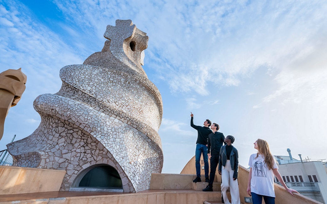 Visitors exploring the unique chimneys on La Pedrera-Casa Milà terrace in Barcelona.