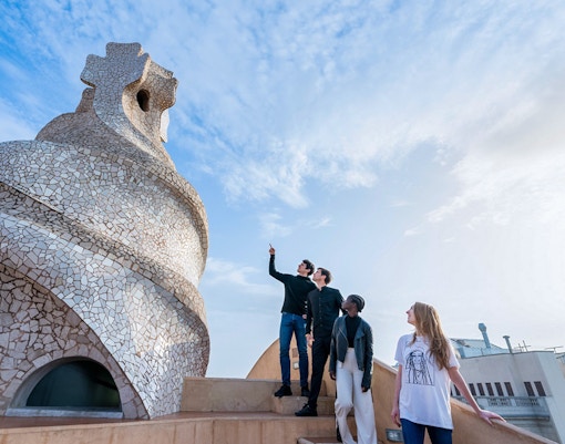Visitors exploring the unique chimneys on La Pedrera-Casa Milà terrace in Barcelona.