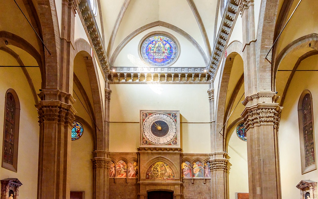 Florence Cathedral interior with ornate columns and a historic clock.