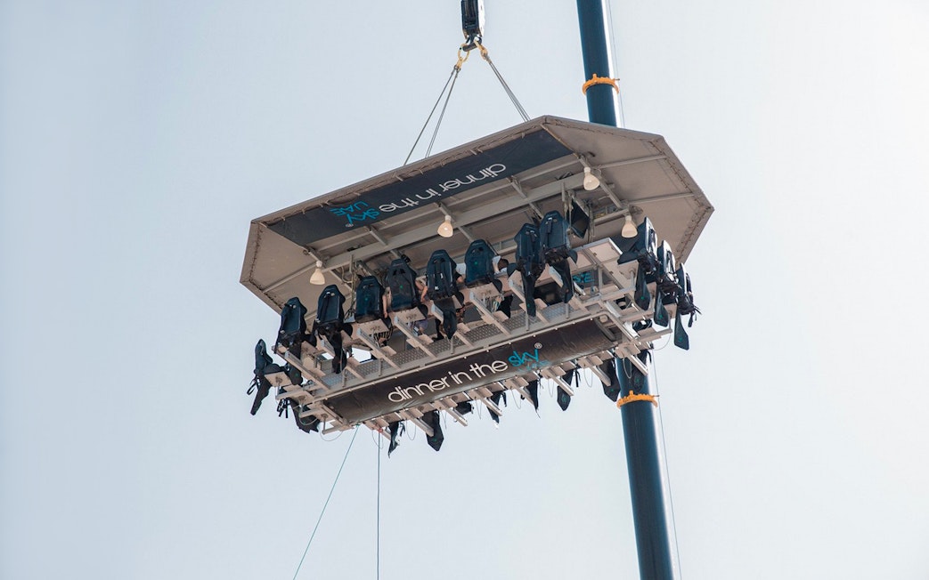 Guests dining on a suspended platform for Dinner in the Sky experience.